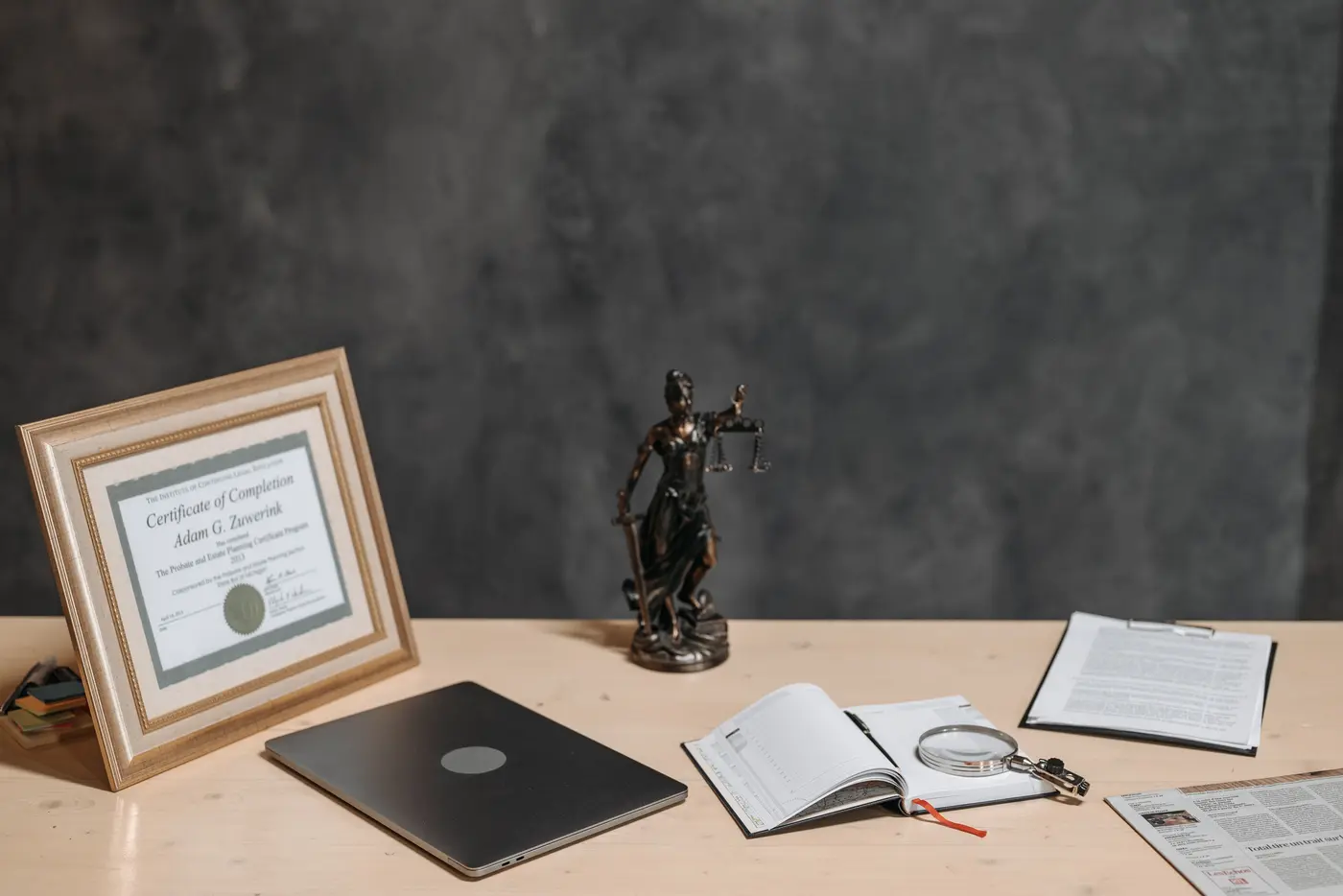 Bureau d'avocat avec une statue de la Justice, un diplôme et un ordinateur